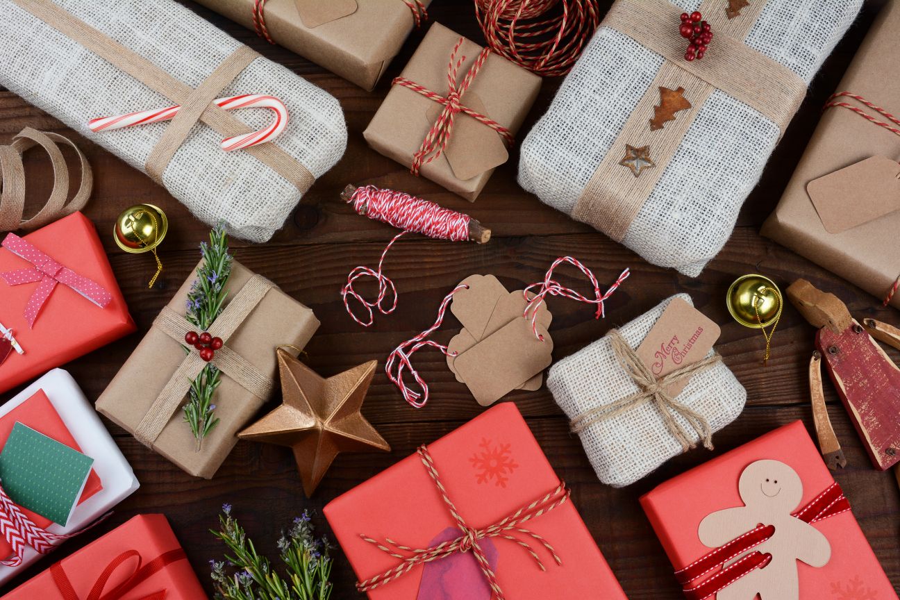 A group of Christmas presents on a dark wood table