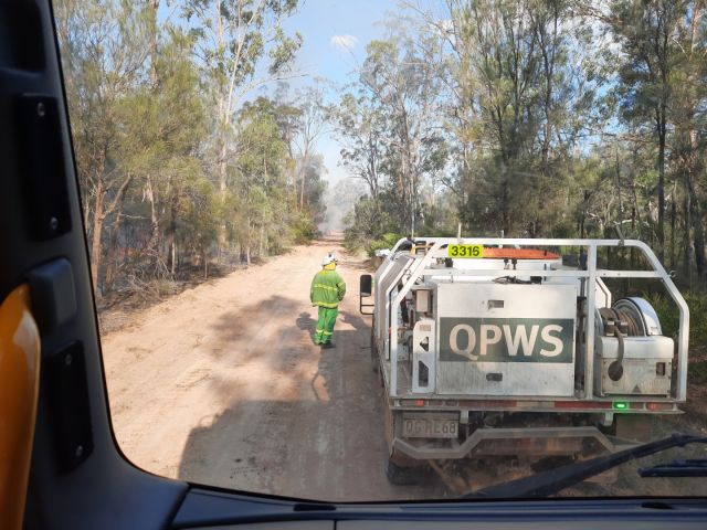 Photo of a QPWS Ranger with a fire truck working with DAF and QFES to contain fires within Barakula and Nudley State Forests.