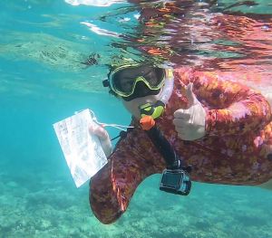 Photo of a snorkeller under water giving a thumbs up.