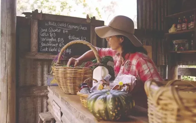 Photo of a women packing a picnic hamper in a rustic setting