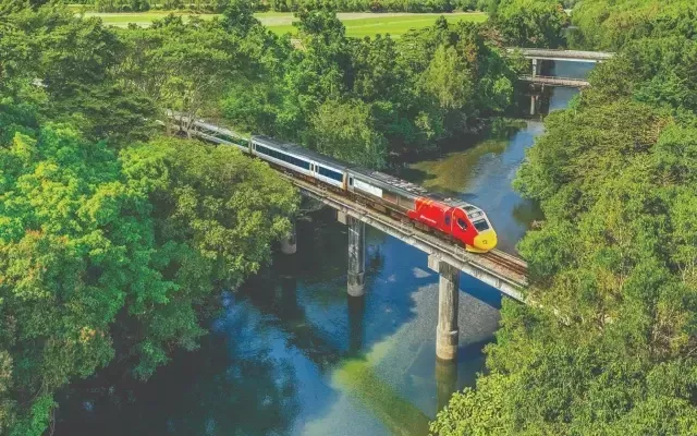 Photo of a fast train crossing a high rail bridge over a river