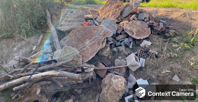 Photo of waste - a mixture of bricks, cement, timber, plastic and plants.
