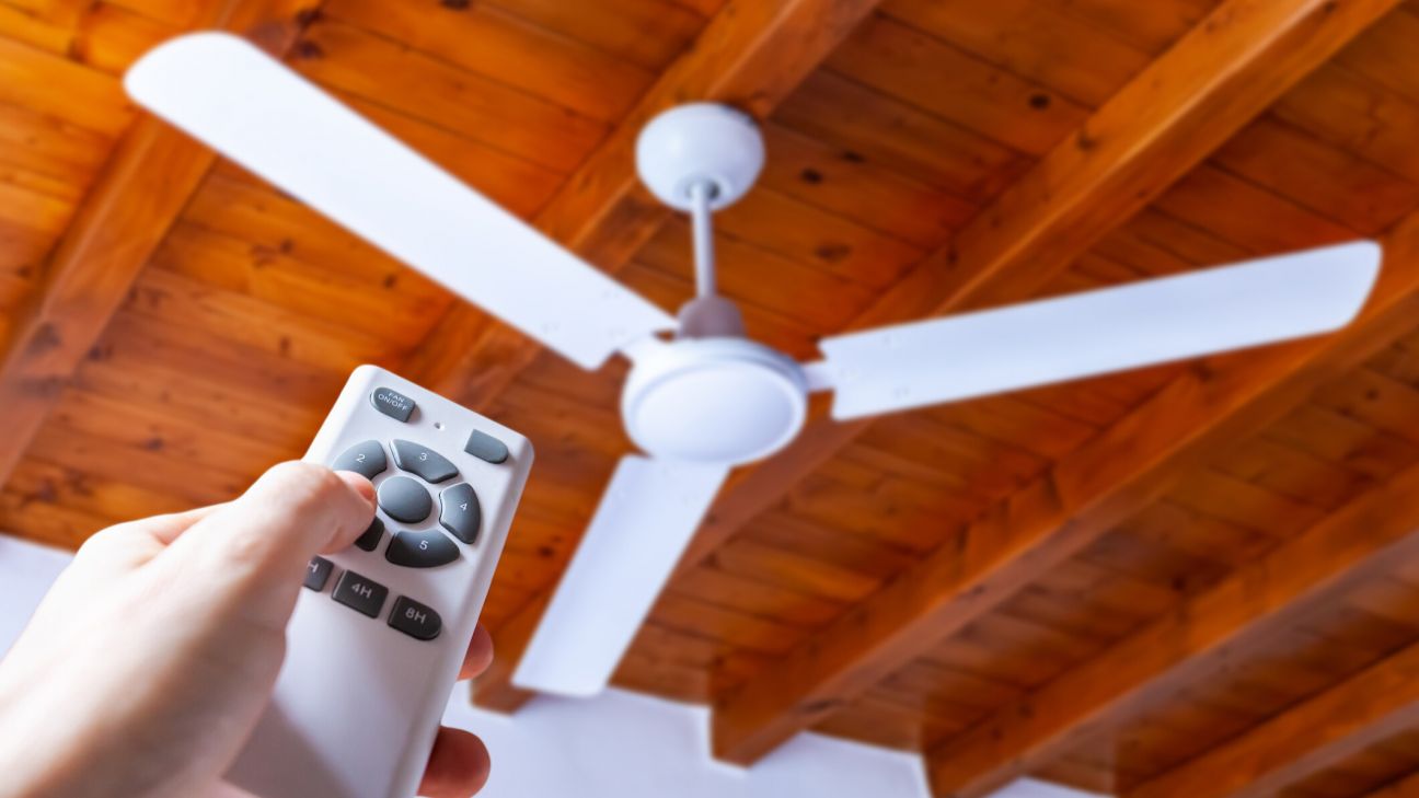 Ceiling fan operating in a home living space as an energy-efficient alternative to air conditioning.